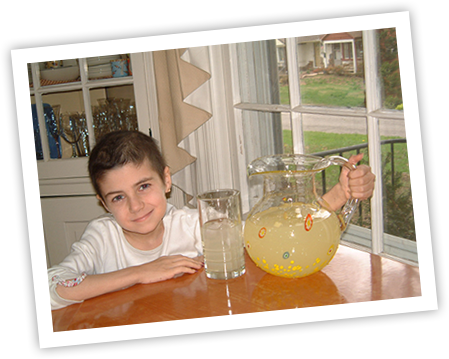 Alexandra Scott at a kitchen table with pitcher of lemonade 